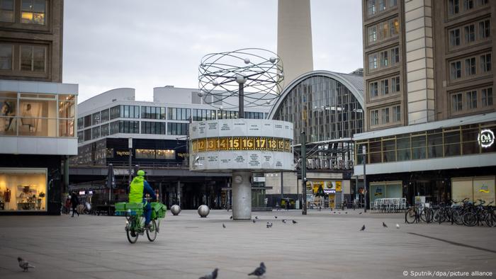 A man rides a bike at an almost empty Alexanderplatz square in Berlin