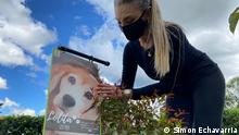 Doris Sanchez visits a small tree planted with the remains of her dog Lolita, who died in 2019. The tree is at a memorial garden outside Medellin run by Pleia.