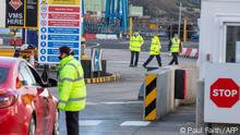 An official checks a motorist as truckers carrying freight from Scotland disembark a ferry at the Port of Larne in County Antrim, Northern Ireland on January 1, 2021, as a new trade border between Northern Ireland and the rest of the UK began operating at 23:00 GMT on December 31, 2020. - In Northern Ireland, the border with Ireland will be closely watched to ensure movement is unrestricted - key to a 1998 peace deal that ended 30 years of violence over British rule as Britain on Friday began a new year and life outside the European Union after leaving the bloc's single market. (Photo by PAUL FAITH / AFP)