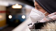 Ein Frau mit FFP2-Maske wartet in einer U-Bahnstation auf die Bahn. In Bayern gilt vom kommenden Montag an eine Pflicht zum Tragen von FFP2-Masken im öffentlichen Nahverkehr und im Einzelhandel.