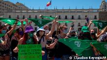 Feminist activists hold up green handkerchiefs -in favour of the decriminalization of abortion- during a demonstration outside La Moneda presidential palace in Santiago on January 13, 2020. (Photo by CLAUDIO REYES / AFP)