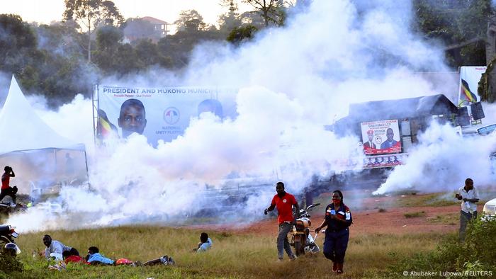 People running under a cloud of tear gas