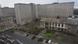 Tall grey and brown buildings with a lower building in front