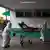 Enfermeiros empurram maca com paciente de covid-19 na entrada de hospital