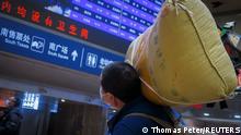 A traveller carries his belongings at a railway station, following the coronavirus disease (COVID-19) outbreak, in Beijing, China January 13, 2021. Picture taken January 13, 2021. REUTERS/Thomas Peter