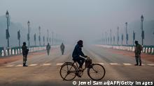 A man rides a bicycle along a street amid smoggy conditions in New Delhi on January 14, 2021. (Photo by Jewel SAMAD / AFP) (Photo by JEWEL SAMAD/AFP via Getty Images)