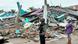 Two men stand next to a hospital that was reduced to rubble Two men stand next to a hospital that was reduced to rubble