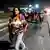Foto de mujer que carga un bebé mientras camina junto a la caravana de migrantes