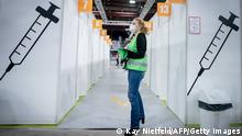 14.01.2021 *** A helper waits inside the Erika-Hess ice stadium that serves as the second vaccination center against the novel coronavirus in Berlin, on January 14, 2021. (Photo by Kay Nietfeld / POOL / AFP) (Photo by KAY NIETFELD/POOL/AFP via Getty Images)