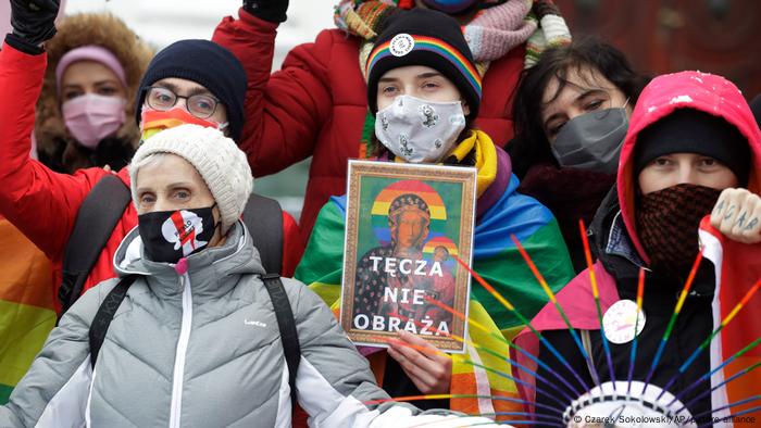 Ein Regenbogen ist keine Beleidigung steht auf dem Plakat mit der angeblich entweihten Schwarzen Madonna von Tschenstochau, dem polnischen Nationalheiligtum, das Demonstrantinnen für dem Gericht in Plock halten