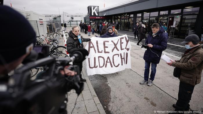 Девушка Катя с плакатом Alexey, udachi во время интервью DW