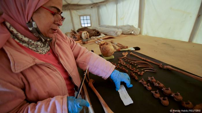 A woman works on artefacts, part of a recent discovery, at the Saqqara necropolis