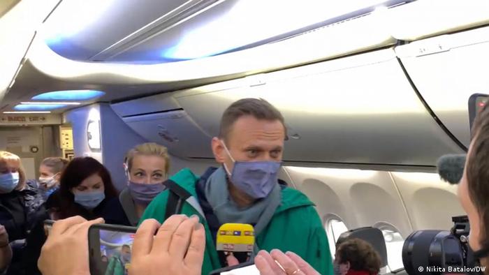 Навальний намагається пройти до свого місця на борту літака