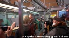 Der russische Oppositionsführer Alexej Nawalny (M) küsst seine Ehefrau Julia, während er von der Polizei bei der Passkontrolle nach der Ankunft am Flughafen Scheremetjewo festgehalten wird. Der Kremlgegner Nawalny ist nach seiner Landung in Moskau noch am Flughafen festgenommen worden. +++ dpa-Bildfunk +++