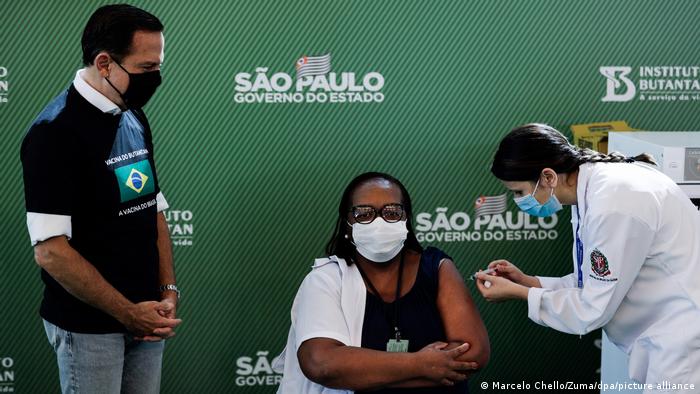 با وجود این، کمپین تزریق واکسن کرونا در برزیل اکنون آغاز شده است و واکسن‌های تولیدی شرکت‌های سینوواک و آسترازنکا در برزیل مجوز گرفته‌اند. کالزاناس (وسط) که پرستاری ۵۴ ساله است، نخستین فرد در برزیل بود که واکسن کرونا را دریافت کرد.