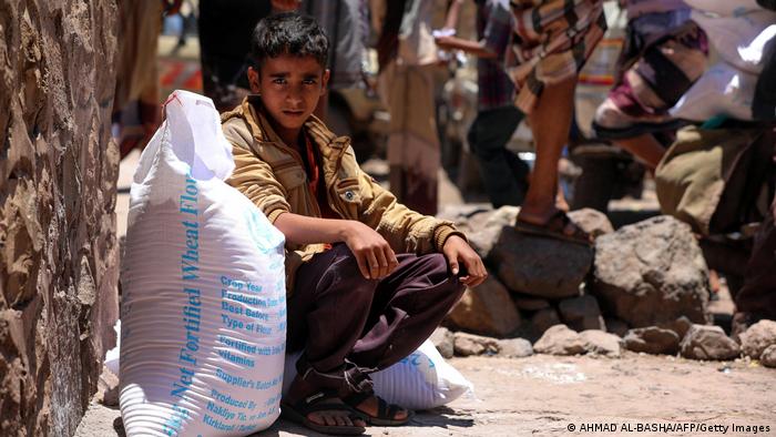  A Yemeni boy receives humanitarian aid, donated by the World Food Programme (WFP), in the country's third city of Taez,.