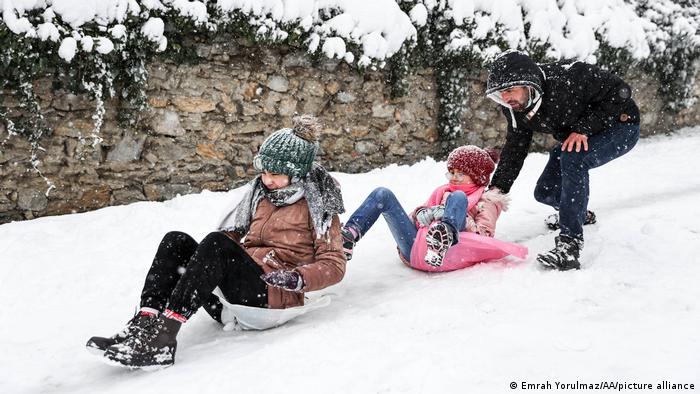 Niños deslizándose en bolsas de plático sobre la nieve.