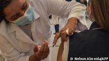 A health worker is inoculated with the CoronaVac vaccine against the novel coronavirus COVID-19 at the Clinicas Hospital in Sao Paulo, Brazil, on January 18, 2021. - Brazil's health regulator gave the green light for the Oxford-AstraZeneca vaccine and China's CoronaVac to be used as the Latin American giant suffers a devastating second wave of the coronavirus. (Photo by Nelson ALMEIDA / AFP)