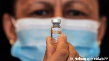 A health worker holds a vial of the CoronaVac vaccine against the novel coronavirus COVID-19 at the Clinicas Hospital in Sao Paulo, Brazil, on January 18, 2021. - Brazil's health regulator gave the green light for the Oxford-AstraZeneca vaccine and China's CoronaVac to be used as the Latin American giant suffers a devastating second wave of the coronavirus. (Photo by Nelson ALMEIDA / AFP)