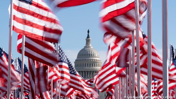 El capitolio de Estados Unidos, detrás de dos filas de banderas estadounidenses.