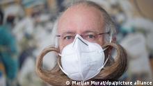 Jürgen Burkhardt, Bartträger und mehrfacher Bartweltmeister, demonstriert das Tragen einer FFP2-Schutzmaske. (zu dpa Bart-Weltmeister Burkhardt hat mit der Schutzmaske keine Probleme) +++ dpa-Bildfunk +++
