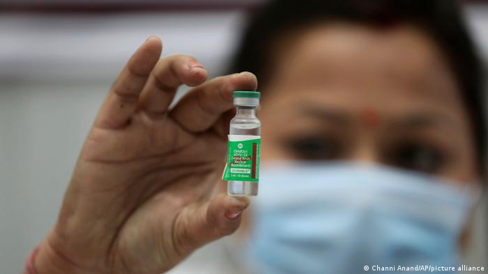 Индийский врач показывает ампулу с вакциной AstraZeneca