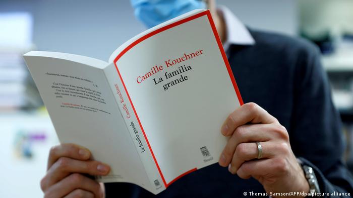 A reader perusing La Familia Grande by Camille Kouchner