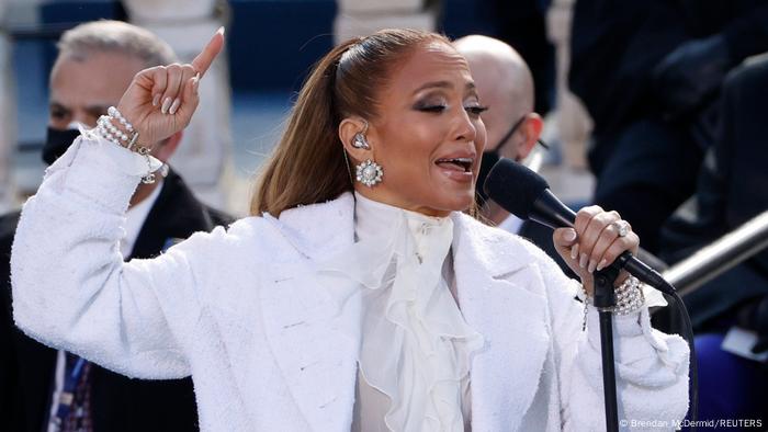 Jennifer Lopez holding microphone and raising a finger