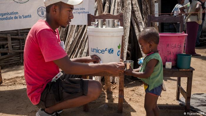 A member of the NGO Action Contre la Faim gives drinking water to an infant during a malnutrition screening session in the Municipality of Ifotaka, in southern Madagascar