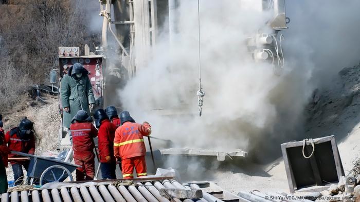 Rescuers work at the explosion site of a gold mine where several miners remain trapped