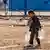 Сирия: дете носи съдове с вода за пиене