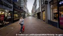 A woman walks along an empty street in Amsterdam, on December 15, 2020, a day after Prime Minister announced a new lockdown to stop the spread of the Covid-19 pandemic caused by the novel coronavirus. (Photo by ROBIN VAN LONKHUIJSEN / ANP / AFP) / Netherlands OUT (Photo by ROBIN VAN LONKHUIJSEN/ANP/AFP via Getty Images)
