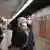 Passageiros usando máscaras cirúrgicas aguardam em plataforma de metrô.
