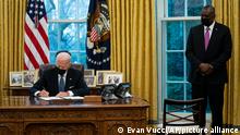 Secretary of Defense Lloyd Austin watches as President Joe Biden signs an Executive Order reversing the Trump era ban on Transgender serving in military, in the Oval Office of the White House, Monday, Jan. 25, 2021, in Washington. (AP Photo/Evan Vucci)
