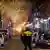 Policial observa chamas em um contêiner na rua em Roterdã