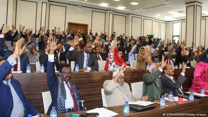 Somali lawmakers raise their hands to confirm the appointment of Prime Minister Mohamed Hussein Roble in 2020