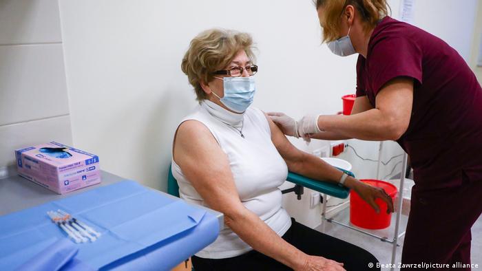 A woman over 80 getting a COVID-19 vaccination