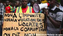 A member of Burkinabe workers' unions and civil society associations holds a placard readign No to impunity - No to violation of liberties - No to corruption - We say NO during a march called by the UAS union to call for better security measures against terrorism, in Ouagadougou on September 16, 2019. (Photo by ISSOUF SANOGO / AFP) (Photo credit should read ISSOUF SANOGO/AFP via Getty Images)