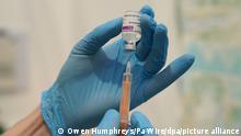 A medical worker prepares an injection with the AstraZeneca jab