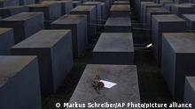 Roses lie with a note saying #weremember, at the Holocaust Memorial on the International Holocaust Remembrance Day, in Berlin, Germany, Wednesday, Jan. 27, 2021. (AP Photo/Markus Schreiber)