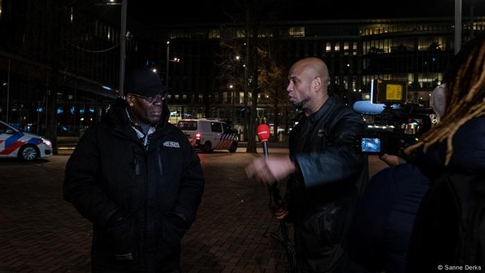 Journalist interviewing a man about the anticipated riots