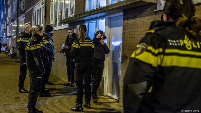 A team of police in Amsterdam speaking to two men