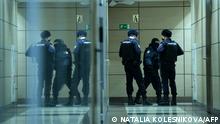 Police officers are seen in a hallway of a business centre, which houses the office of opposition leader Alexei Navalny's Anti-Corruption Foundation (FBK), in Moscow on January 27, 2021. - Russian authorities on January 27 ramped up pressure on the opposition, searching the apartments and offices of jailed Kremlin critic Alexei Navalny ahead of new protests called for the weekend to demand his release. Ivan Zhdanov, the head of Navalny's FBK Anti-Corruption Foundation, said police were searching flats linked to Navalny and the foundation's offices for alleged violations of coronavirus restrictions. (Photo by NATALIA KOLESNIKOVA / AFP)