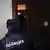 A Russian police officer opens a house door