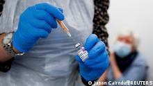 FILE PHOTO: A health worker fills a syringe with a dose of the Oxford/AstraZeneca COVID-19 vaccine at the Appleton Village Pharmacy, amid the coronavirus disease (COVID-19) outbreak, in Widnes, Britain, January 14, 2021. REUTERS/Jason Cairnduff/File Photo