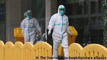 Staffs wearing protective clothing carry trash from a hotel where members of the WHO International Investigation Team are believed to have been quarantined in Wuhan City, Hubei Province, China on January 28, 2021. The team will investigate the new coronavirus COVID-19 in Wuhan. ( The Yomiuri Shimbun via AP Images )