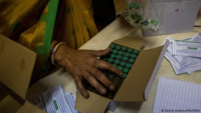 An Indian health worker counts vials