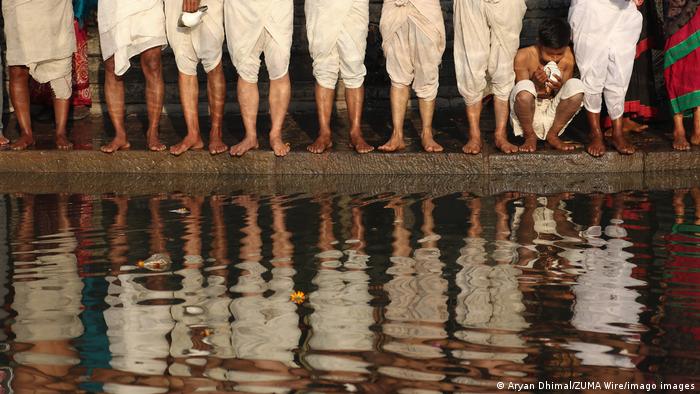 شماری از هندوهای نیپال در حاشیه رودخانه شالی در جریان جشنواره مذهبی سواتانی براتا کاتا منتظر داخل شدن به آب هستند. این جشواره مذهبی هندوها در نیپال نیز مثل همه رویدادها و مراسم مذهبی دیگر در جهان از همه گیری ویروس کرونا متاثر شده است.