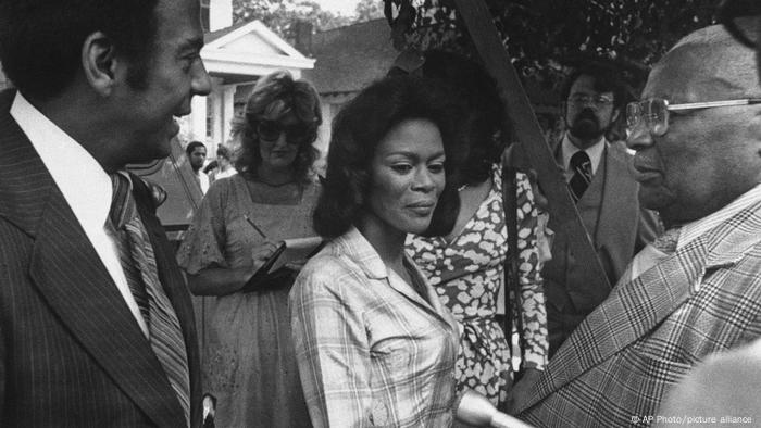 A black and white photo from a film set, Cicely Tyson stands between two men