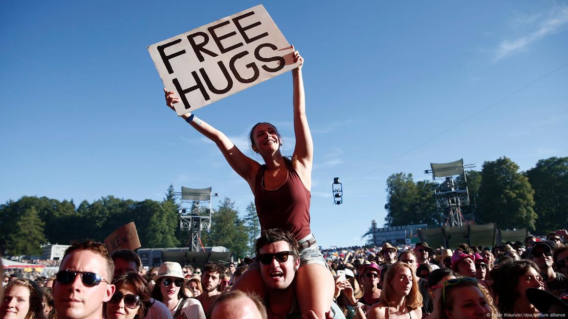 Se ve una chica con un cartel que pone "abrazos gratis".